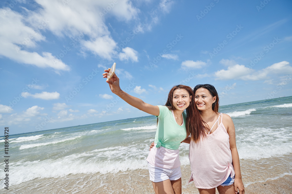 Pretty young Asian girls taking selfie on the beach Pretty young Asian girls taking selfie on the beach