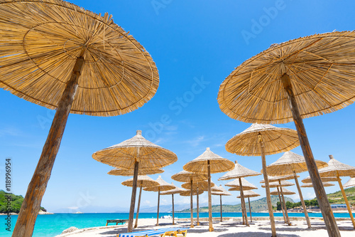Fototapeta Naklejka Na Ścianę i Meble -  Sunshade beach umbrellas with sky and sea background.  Selective focus.