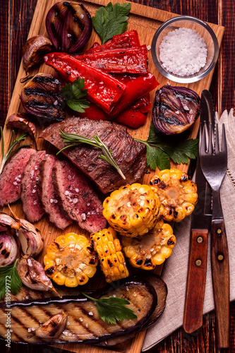 Grilled steak and vegetables on cutting board.