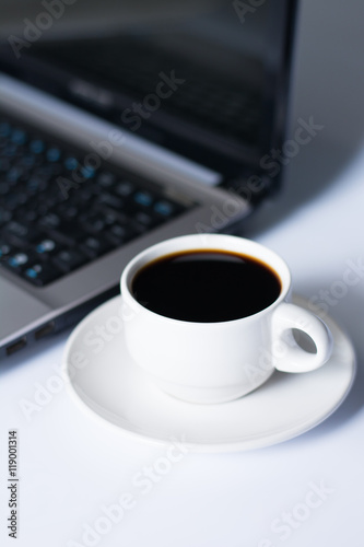Laptop and coffee cup on white