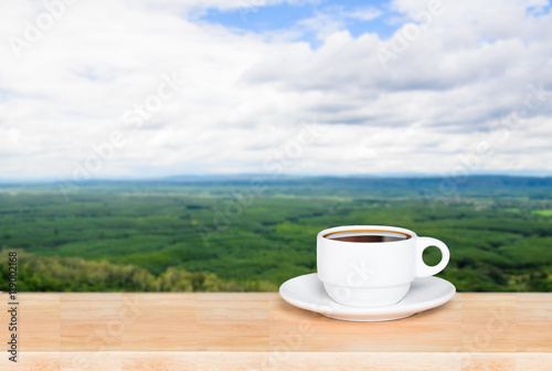 Cup with coffee on table and landscape