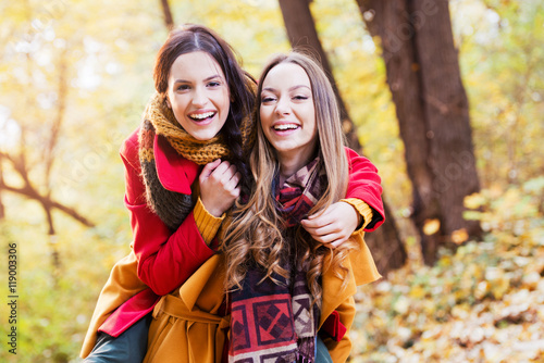 Two beautiful young women enjoying in the park on an autumn day  © Tijana