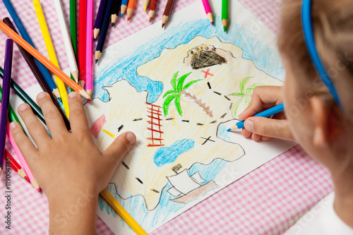 Child paints a picture of pencils pirate treasure map.