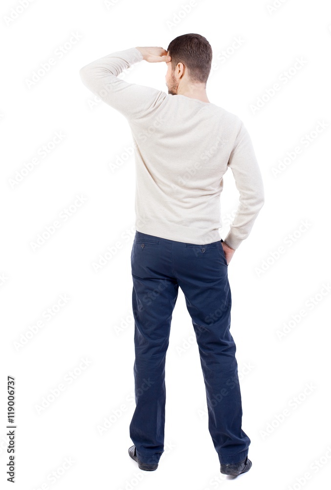Back view of man . Standing young guy. bearded man in a white warm sweater covers her eyes. Back view of man . Standing young guy. bearded man in a white warm sweater covers her eyes.