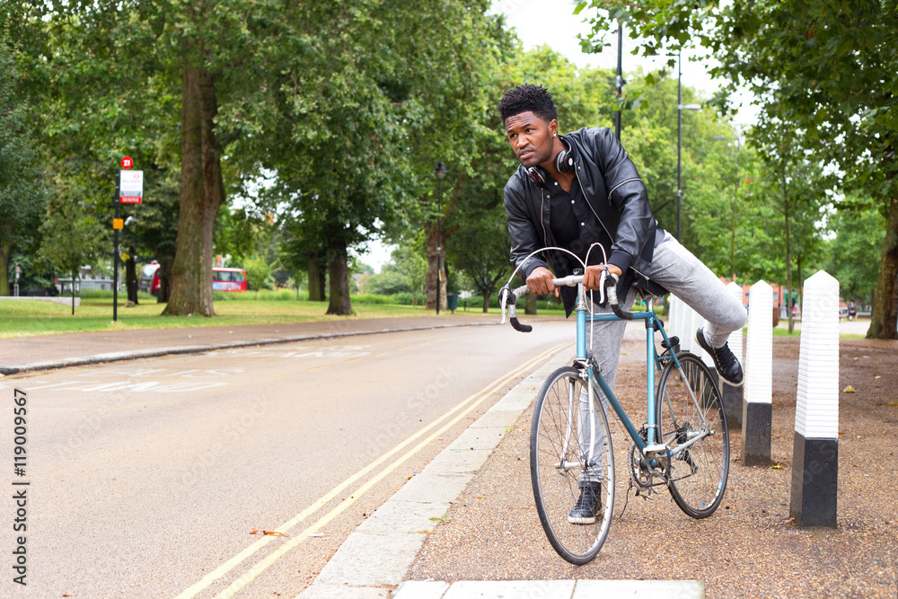 Young man in a hurry getting on his bike