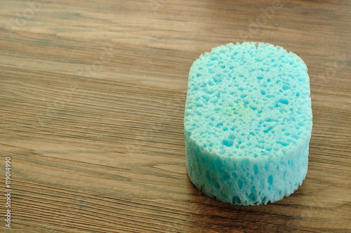 A blue bath sponge isolated on a wooden background