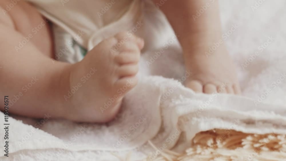 Little baby lie on table. Motherhood. Feets movements. Cute. Child Happiness Little baby lie on table. Motherhood. Feets movements. Cute. Child Happiness