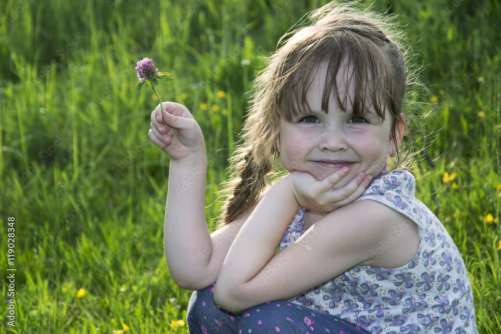 Little girl holding a clover in her hand. Little girl holding a clover in her hand.