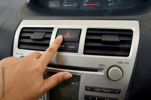 Hand touching emergency button in car