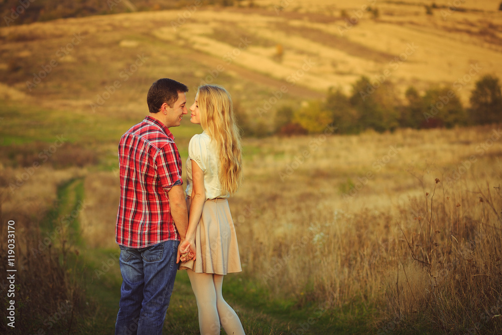 A moment before a kiss between sweet couple standing on the fiel