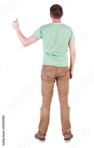 Back view of  man in green t-shirt shows thumbs up.   Rear view people collection.  backside view of person.  Isolated over white background. © ghoststone