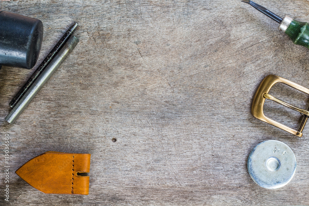 Naklejka premium Leather and craft tools on wooden background