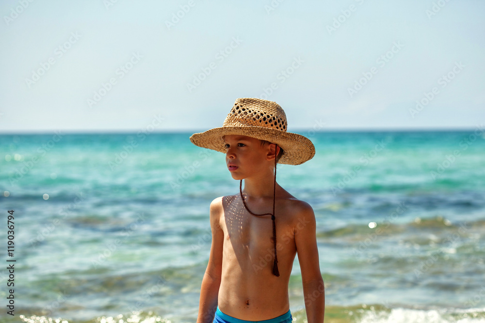 Boy with western hat seriously looking around in summer