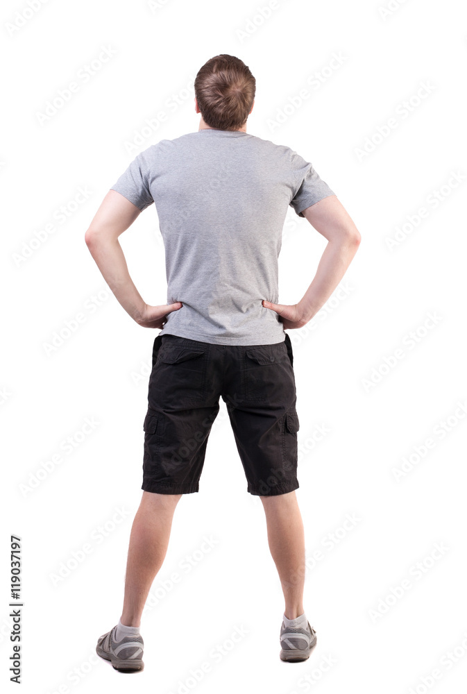 Back view of handsome man in t-shirt and  shorts  looking up.   Standing young tourist. Rear view people collection.  backside view of person.  Isolated over white background. her hands on her hips