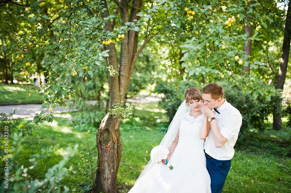 Wedding couple at park near trees and bushes