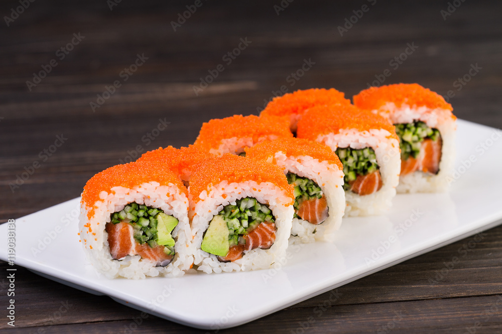 Sushi roll on plate on wooden background . They were 8 pieces .