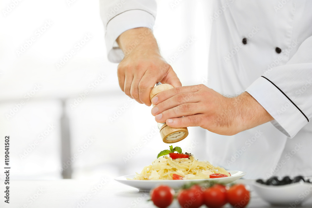 Chef preparing delicious pasta in kitchen Chef preparing delicious pasta in kitchen