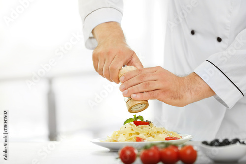 Chef preparing delicious pasta in kitchen