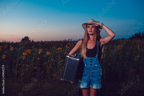 Young woman with retro suitcase traveling in countryside, summer nature outdoor