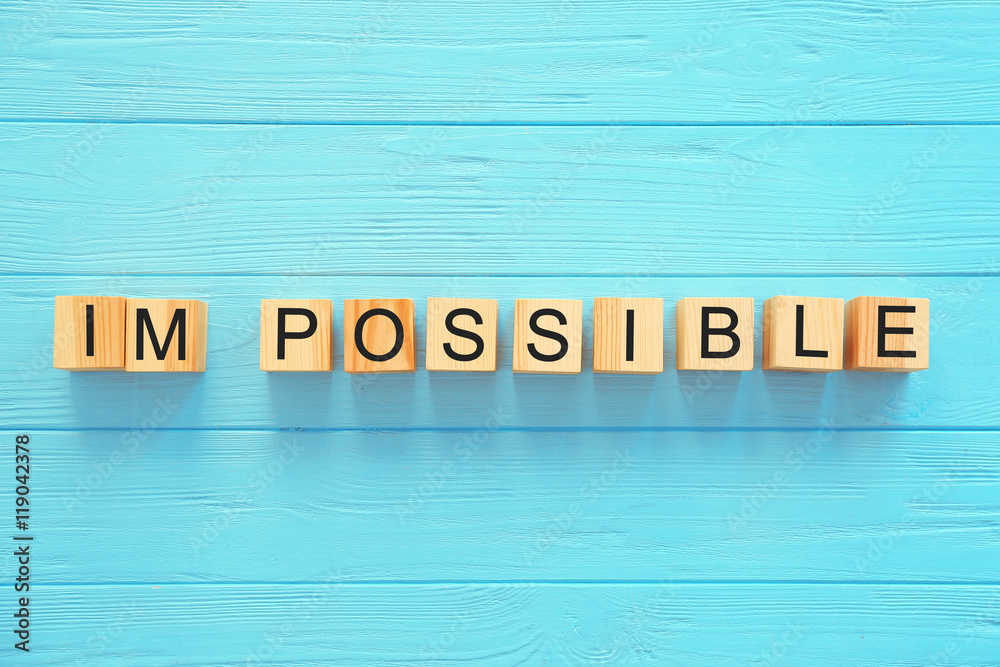 Cubes with word IMPOSSIBLE on wooden background Cubes with word IMPOSSIBLE on wooden background