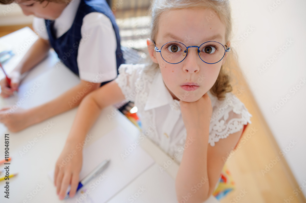 Fototapeta premium Two young student of an elementary school sitting at a desk.