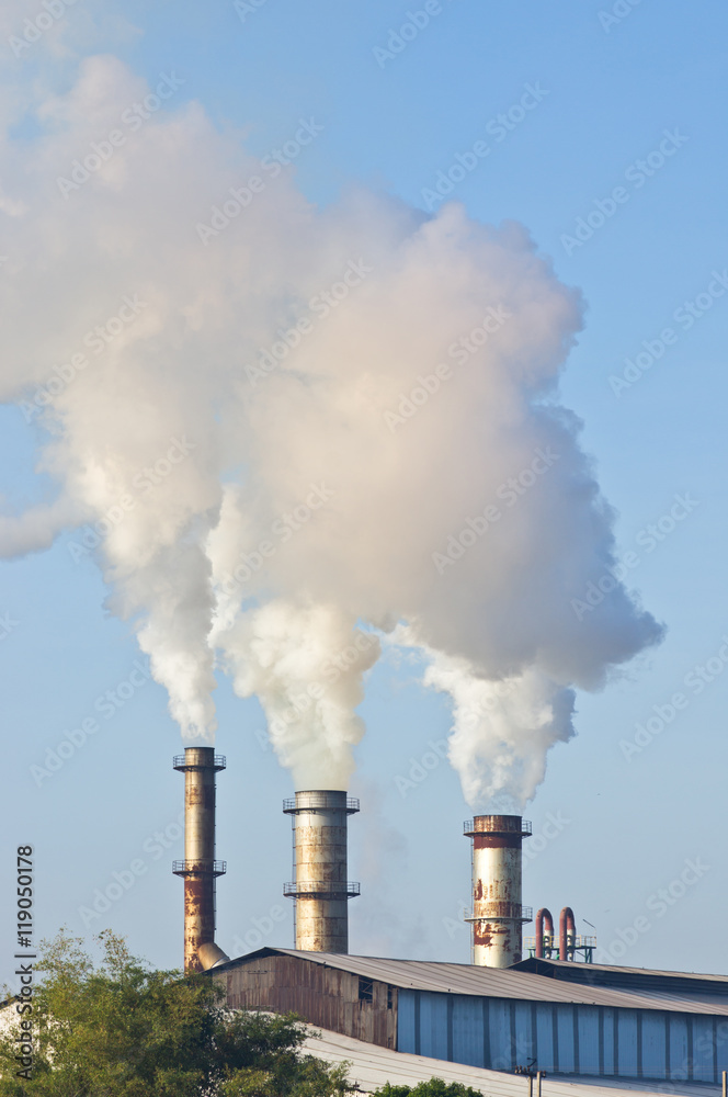 three of factory smokestack against morning sunlight three of factory smokestack against morning sunlight