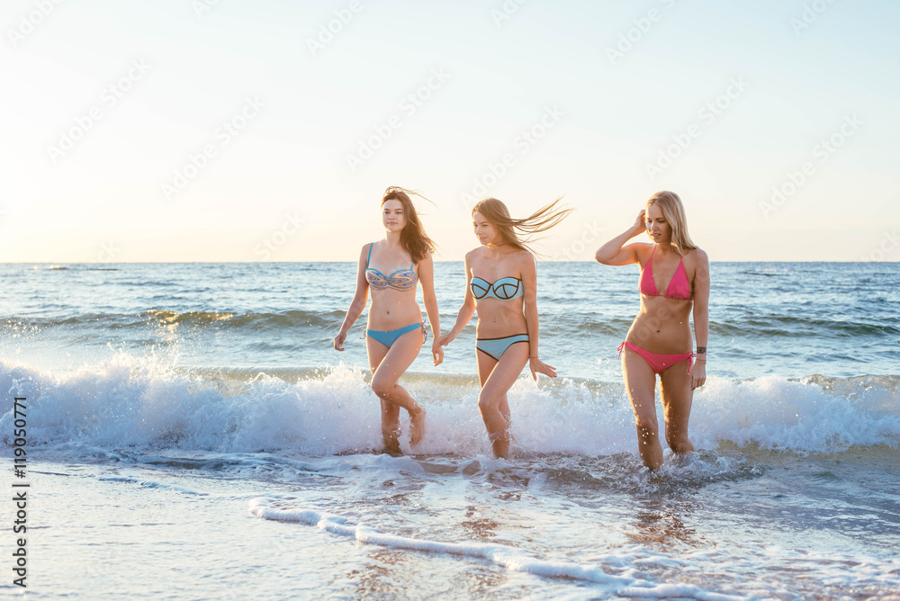 three girls having fun on beach, friends on beach in sunset light