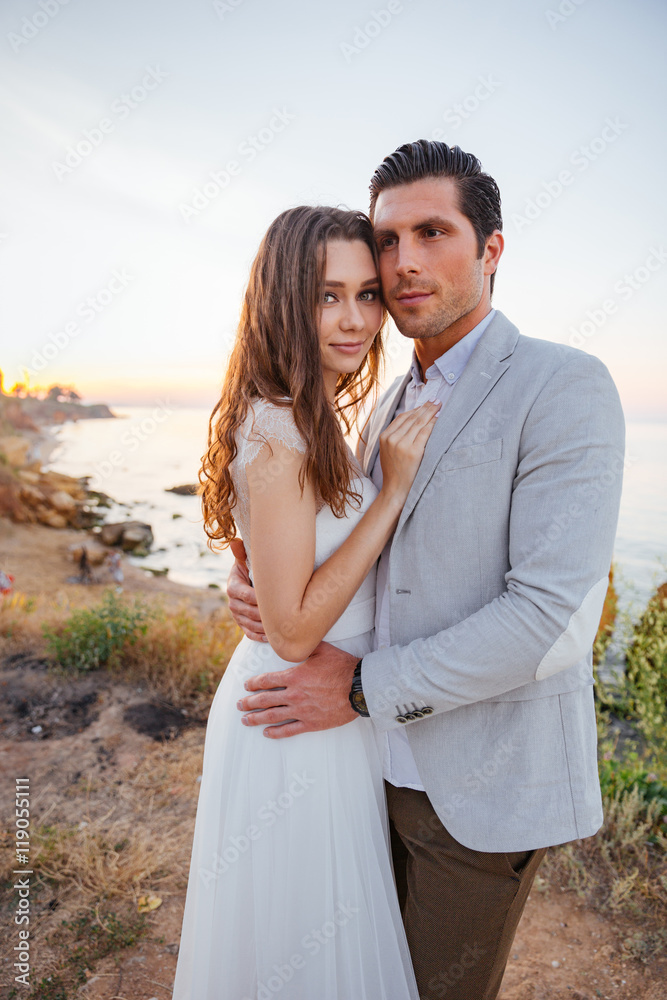 Romantic married couple standing on the beach Romantic married couple standing on the beach