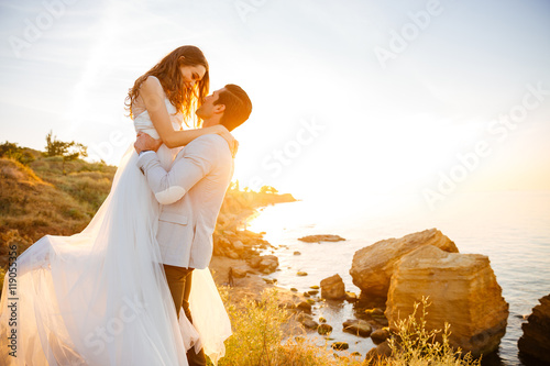 Attractive bride and groom getting married by the beach
