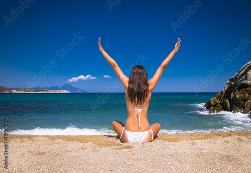 Beautiful woman vawing and enjoying on beach. Greece. photo