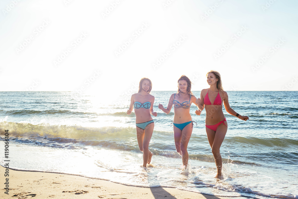 three girls having fun on beach, friends on beach in sunset light