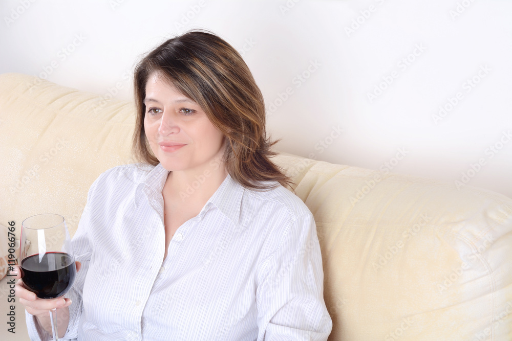 Woman relaxed on sofa with a glass of wine. Woman relaxed on sofa with a glass of wine.