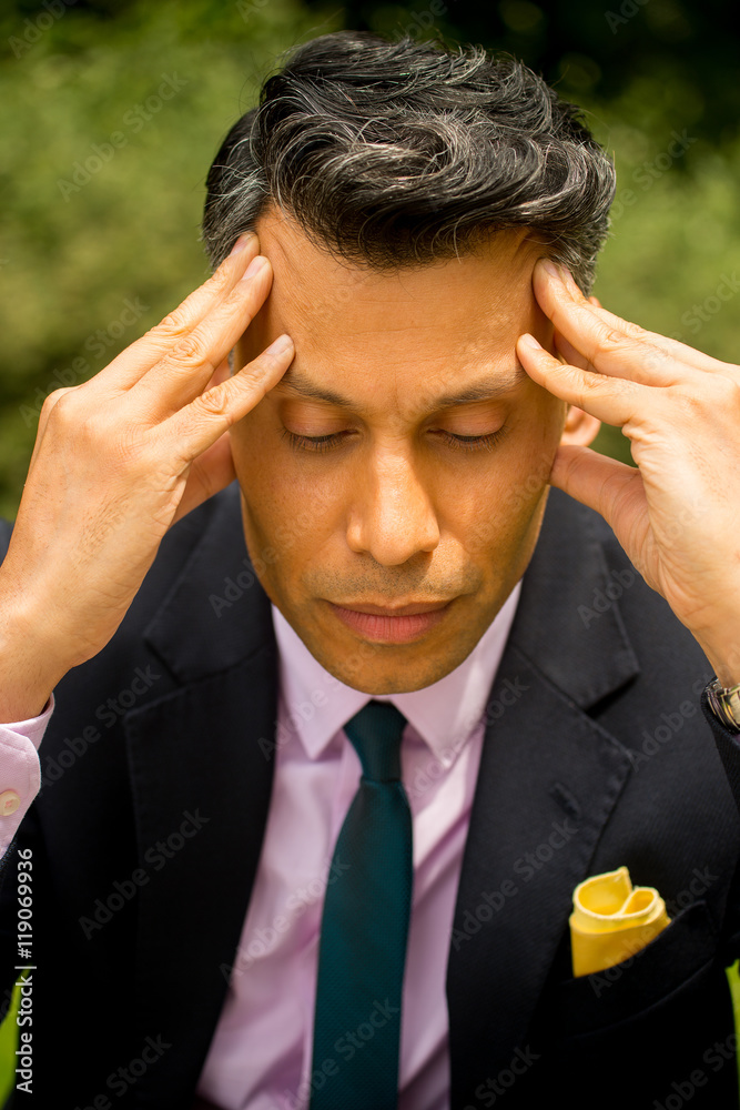 Businessman with eyes closed and his head in his hands. Businessman with eyes closed and his head in his hands.