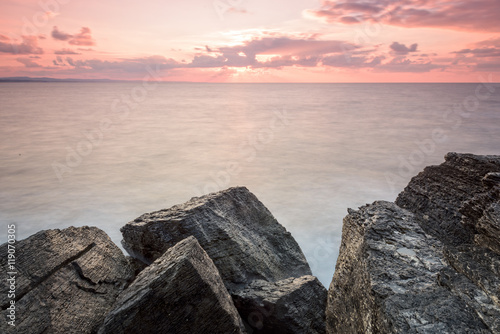 there are pink rocks near to sea with long exposure shot