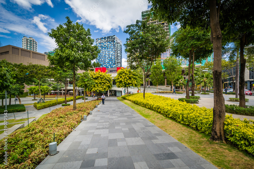 Fototapeta premium Walkway at a park and skyscrapers at Bonifacio Global City, in T