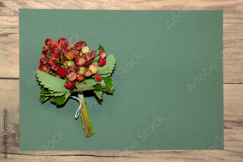 Bouquet of fresh strawberries on green craft paper.