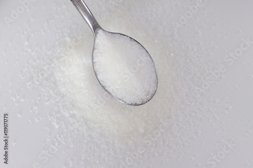 spoon of sugar on a background of scatter of sugar