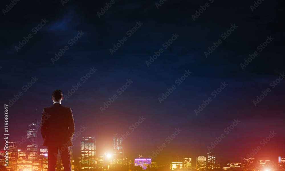 Businessman viewing night glowing city