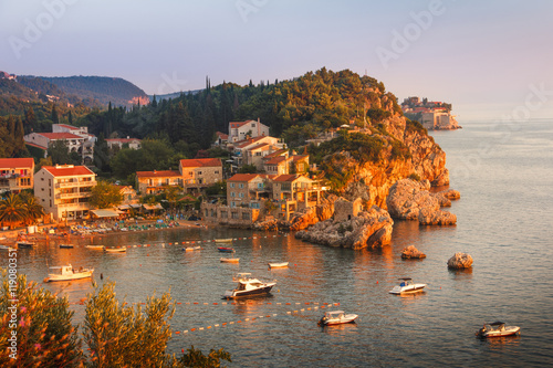 Fototapeta Naklejka Na Ścianę i Meble -  View of the village Przno on a rocky beach in a picturesque bay at sunset. Adriatic Sea. Budva Riviera. Montenegro.