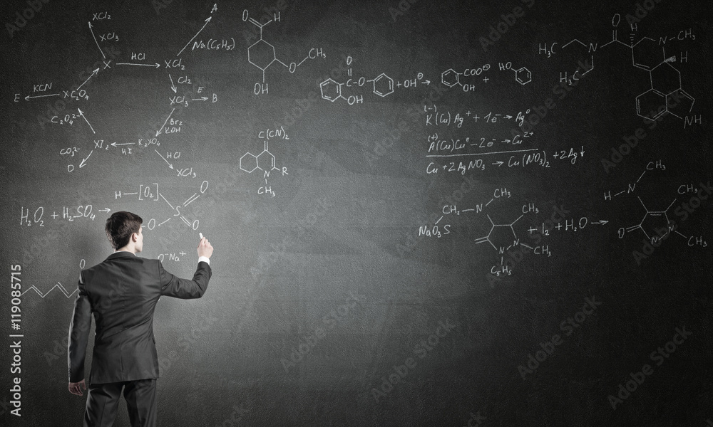 Scientist writing formulas on chalkboard Scientist writing formulas on chalkboard