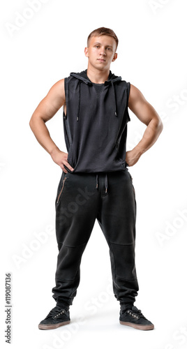 Full lenght portrait of muscled young man with his hands on hips