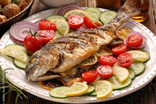 Grilled fish with roasted potatoes and vegetables on the plate