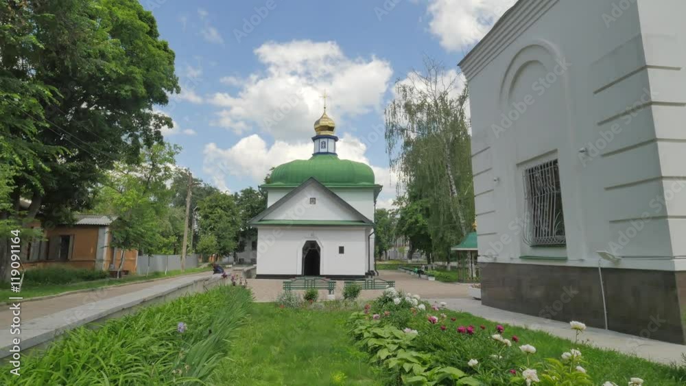 People in Church Courtyard Panorama Green Roofed Church People Sitting on a Benches Near Church Residental House Sunny Day Flower Beds Trees Lawns People in Church Courtyard Panorama Green Roofed Church People Sitting on a Benches Near Church Residental House Sunny Day Flower Beds Trees Lawns