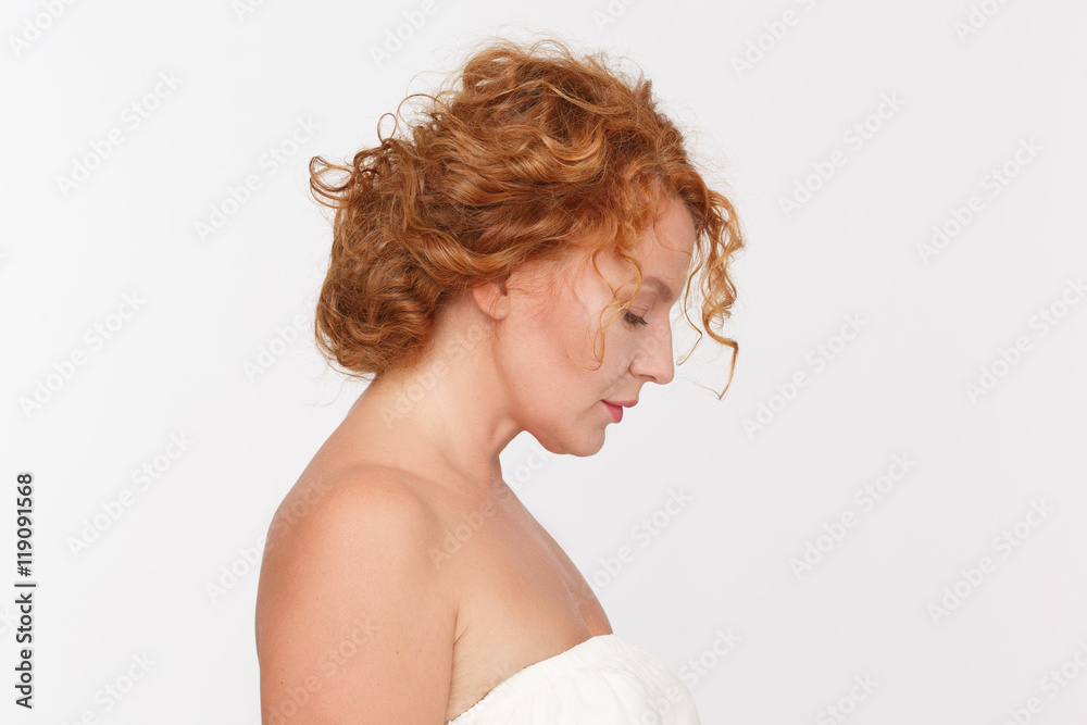 Beauty and emotions concepts. Profile of sad mature or middle aged woman posing isolated on white background in studio. Beauty and emotions concepts. Profile of sad mature or middle aged woman posing isolated on white background in studio.