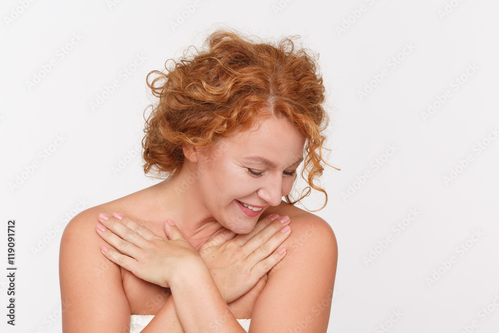 Beautiful red haired woman smiling for camera isolated on white. Pretty middle aged lady looking down in studio. Emotions concept. Beautiful red haired woman smiling for camera isolated on white. Pretty middle aged lady looking down in studio. Emotions concept.