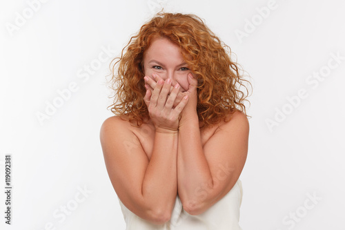 Portrait of pleasanty shocked mature woman isolated on white background. Beautiful middle aged woman with red hair in studio.