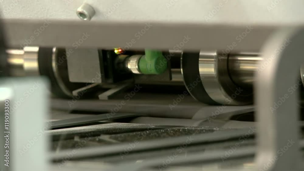 Printed sheets coming out of commercial printing press Printed sheets coming out of commercial printing press