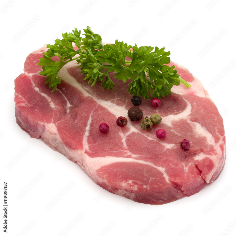 Raw pork neck chop meat with parsley herb leaves and peppercorn Raw pork neck chop meat with parsley herb leaves and peppercorn