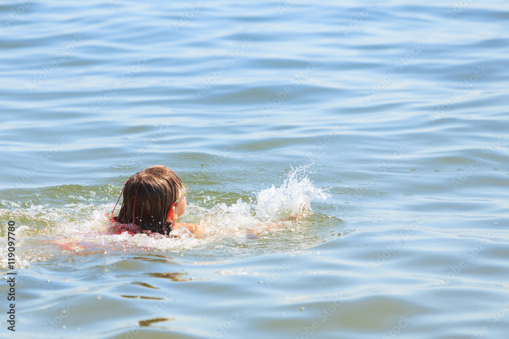 Little girl kid swimming in sea water. Fun