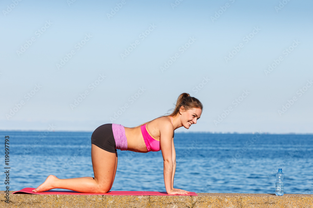 Woman doing sports exercises outdoors by seaside Woman doing sports exercises outdoors by seaside